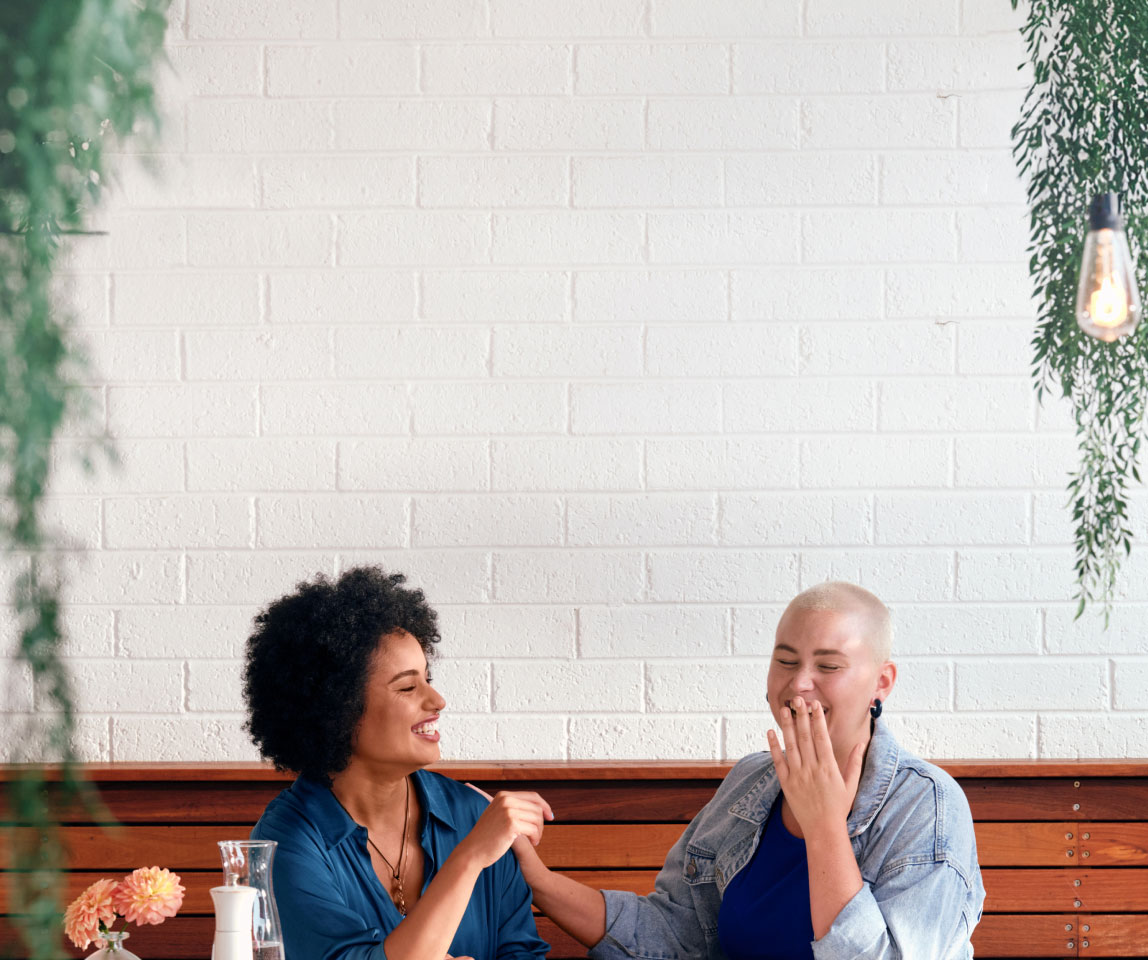 Two girls were sitting and laughing happily with each other.